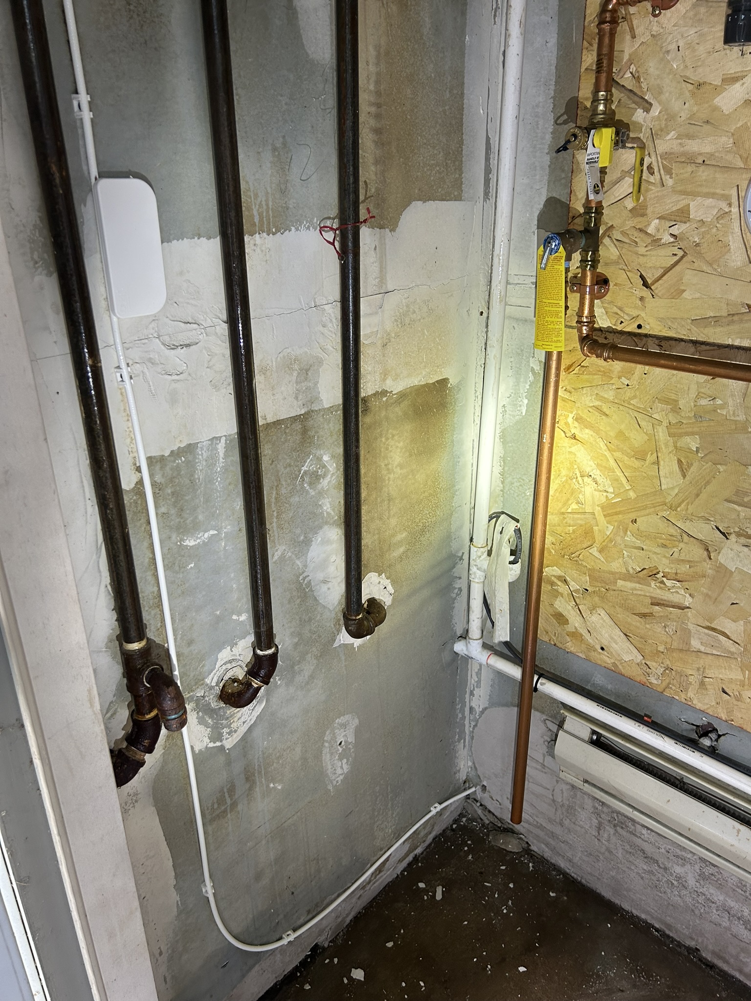 Nashua utility room after: wall behind piping cleaned