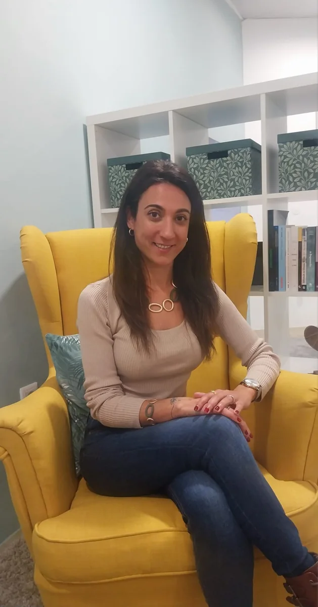 Dra. Bianca Soares, sentada numa poltrona amarela na sala de consulta
