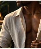 A confident adult man in a softly open linen shirt, lit warmly