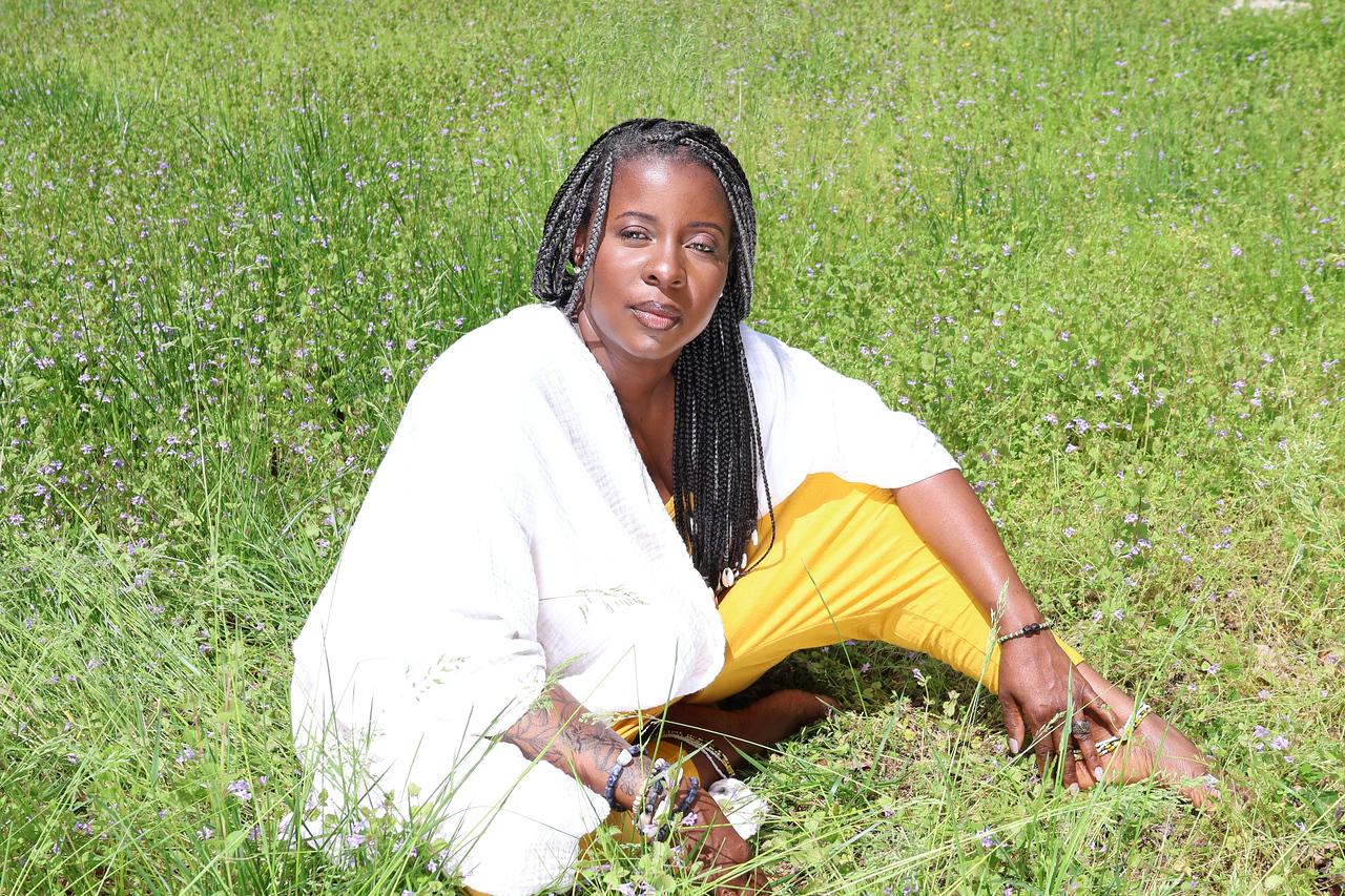 Dr. Za'Yn Muhammad seated in a green meadow