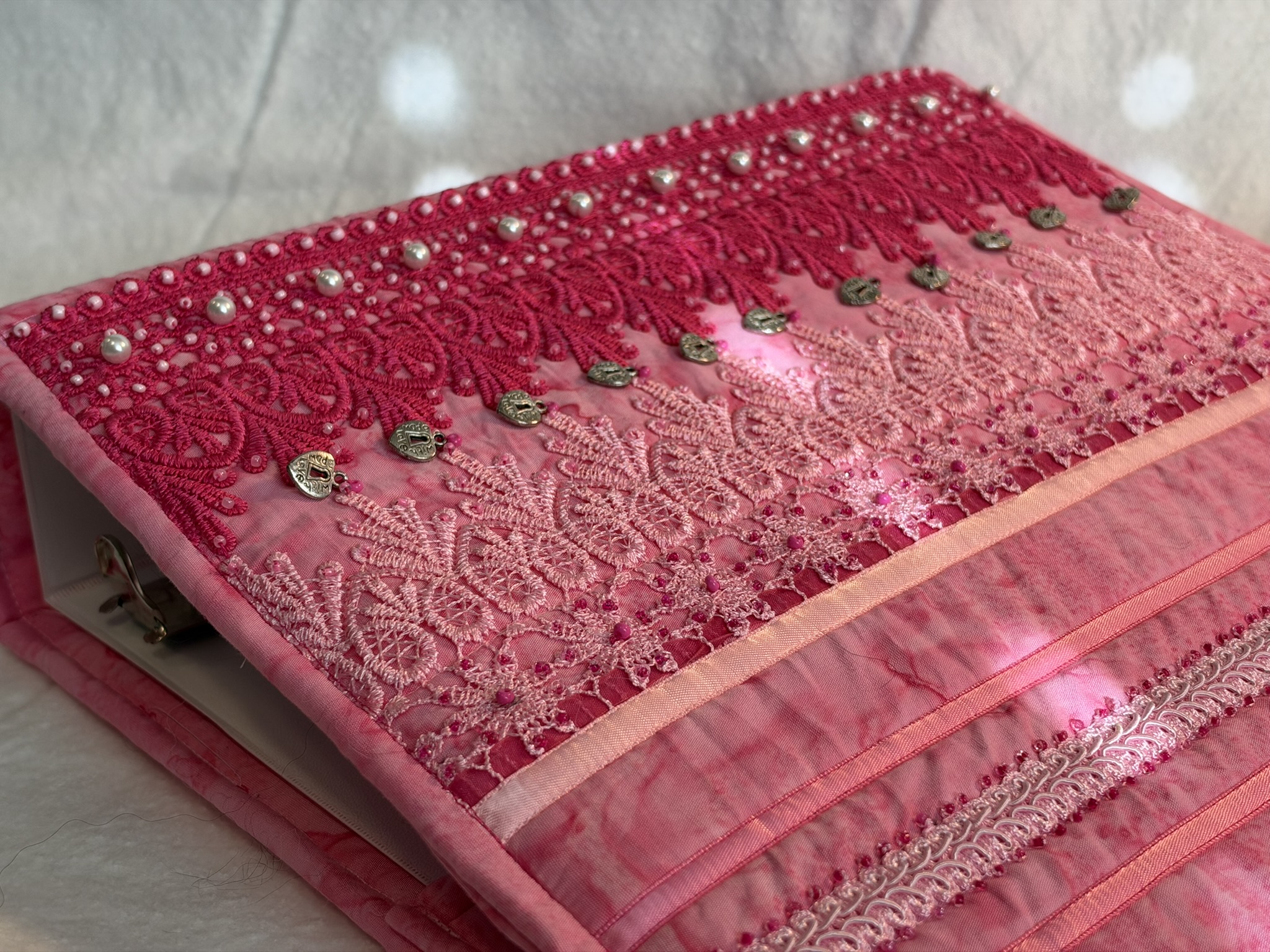 Pink quilted binder cover with layered lace, pearls, and silver heart charms