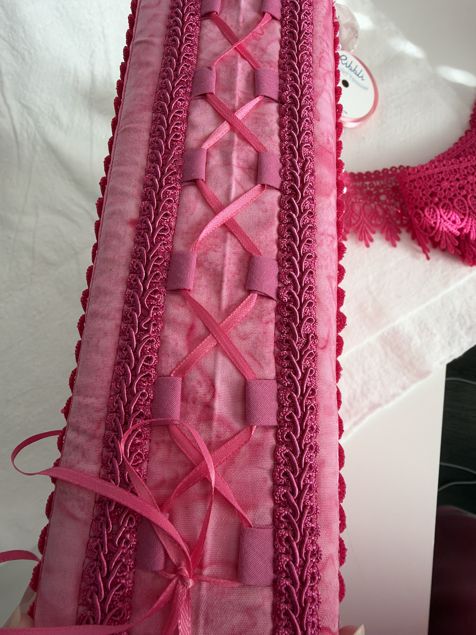 Ribbon lacing through bias-tape tabs between rows of gimp
