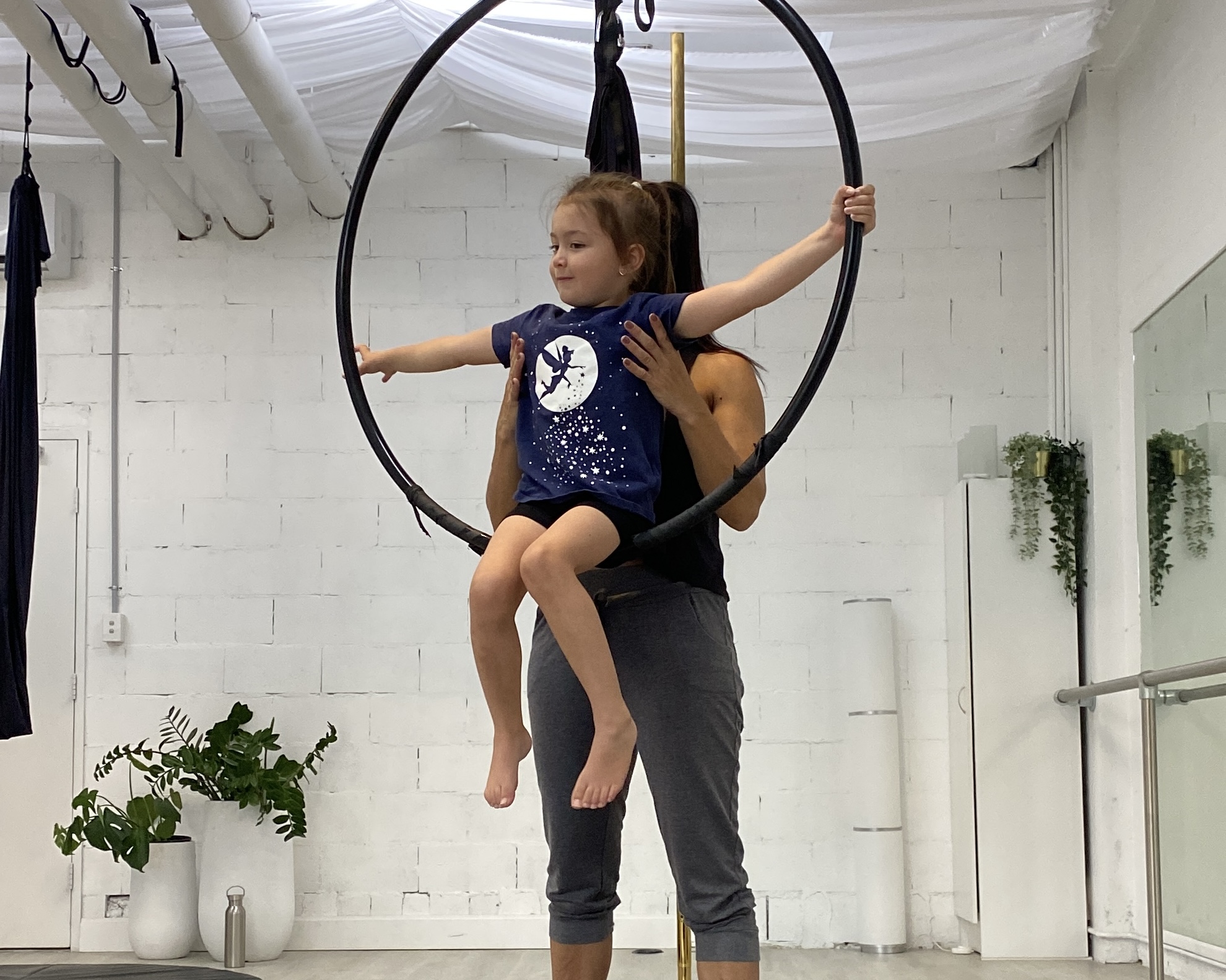 Kids and coach across the studio during an Aerial Fit Kids session