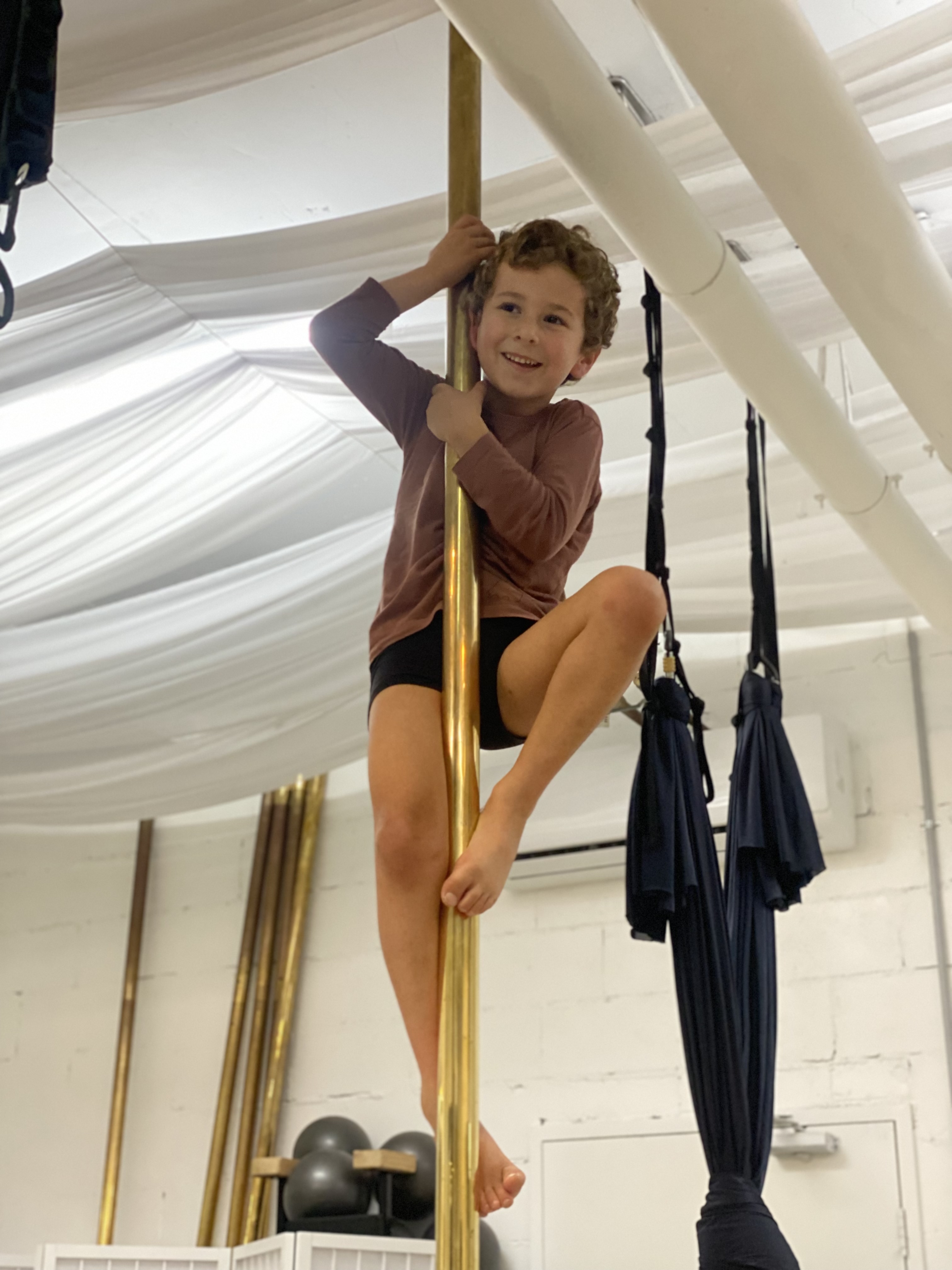 Child climbing the pole at Achieve Pole Studio