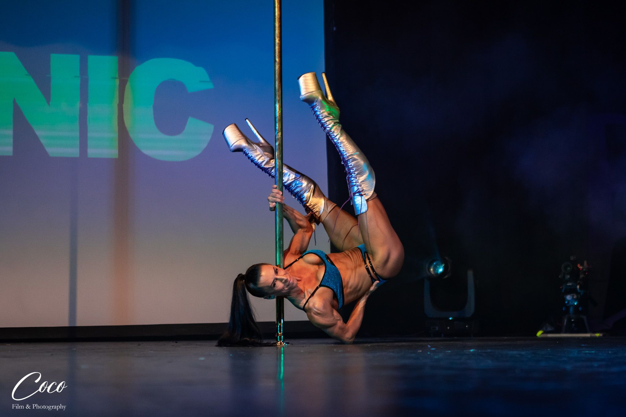 Natty Stephens, Australian pole coach and performer, inverted on the pole on stage