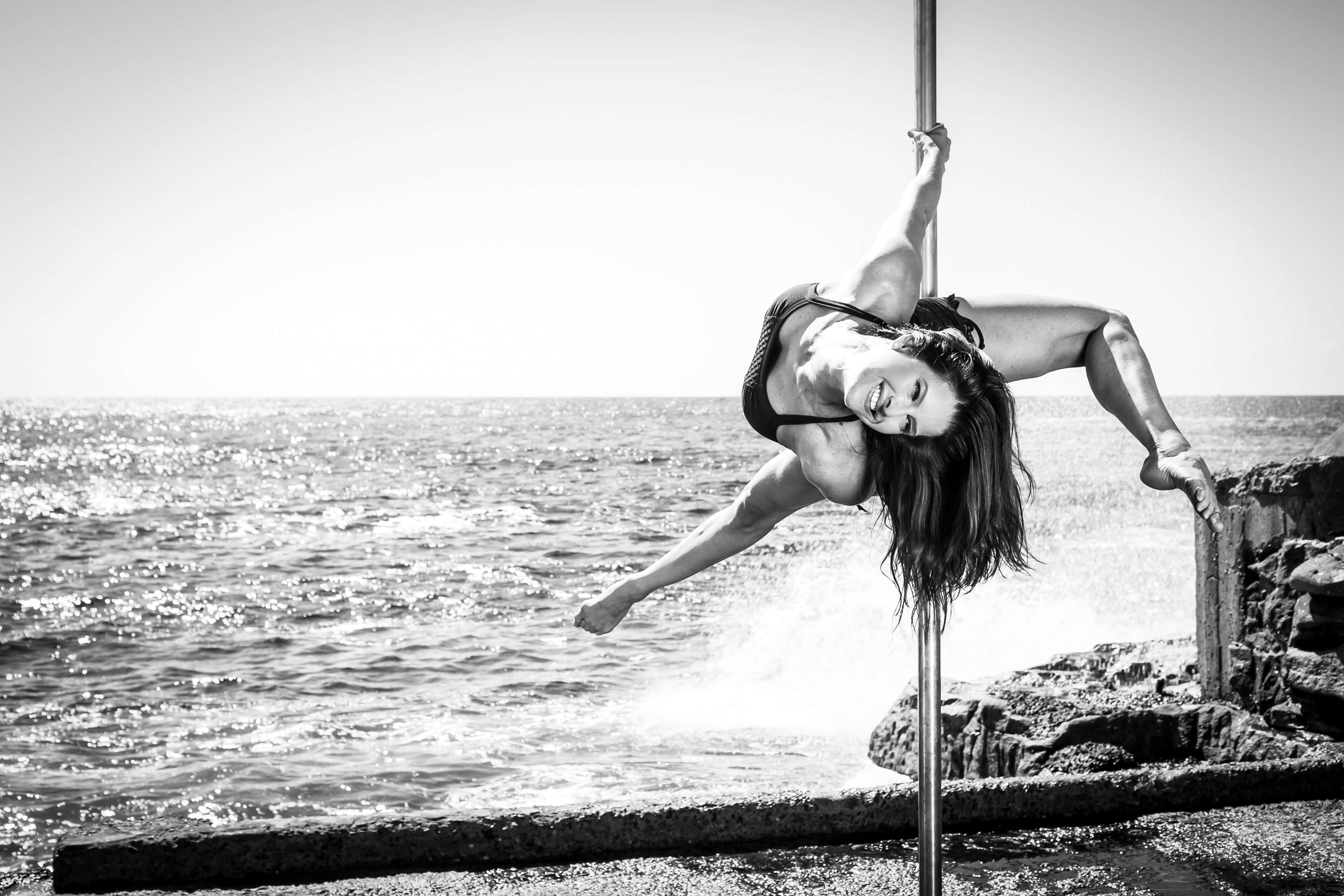 Andrea Ryff, two-time world pole champion, performing on a pole by the ocean