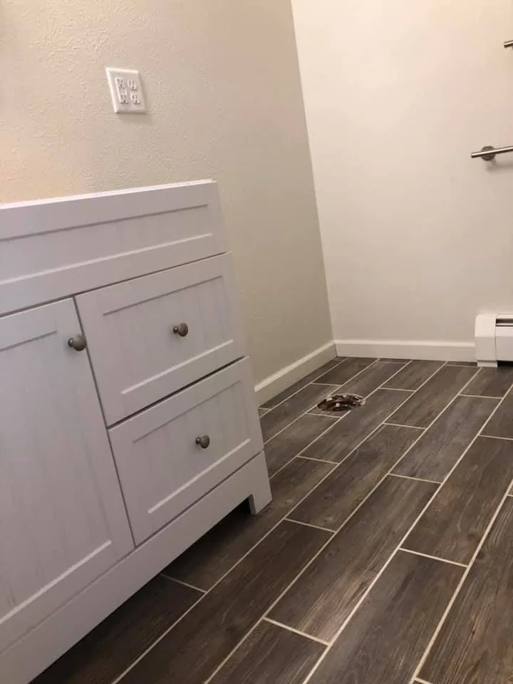 Bathroom vanity cabinet installed against a freshly finished wall