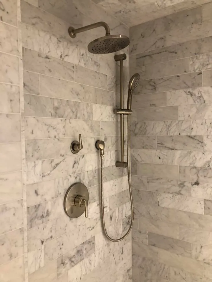 Marble-look shower wall with rainfall head, handheld sprayer and mixer valve