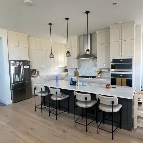 Finished kitchen with a large island, pendant lighting and dark cabinetry