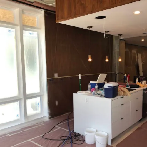 Interior painting underway in a Denver kitchen with cabinetry masked off
