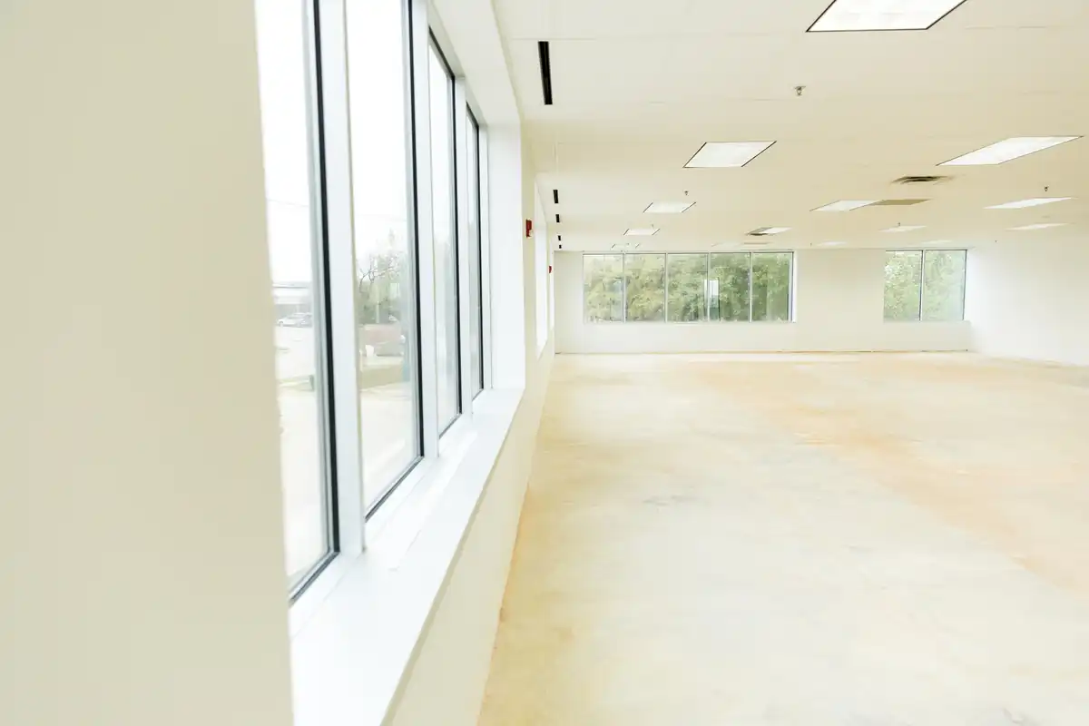 Bright interior with finished drywall walls and a run of windows along one side