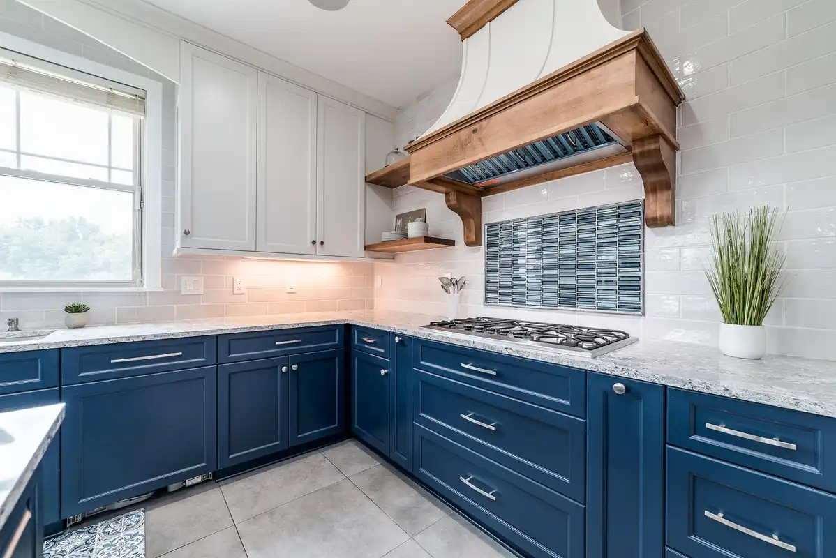 Finished kitchen with navy cabinetry and a timber range hood