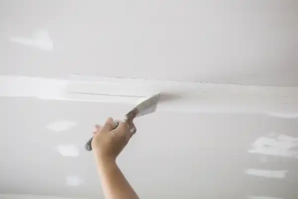 Drywall repair work being finished on an interior wall