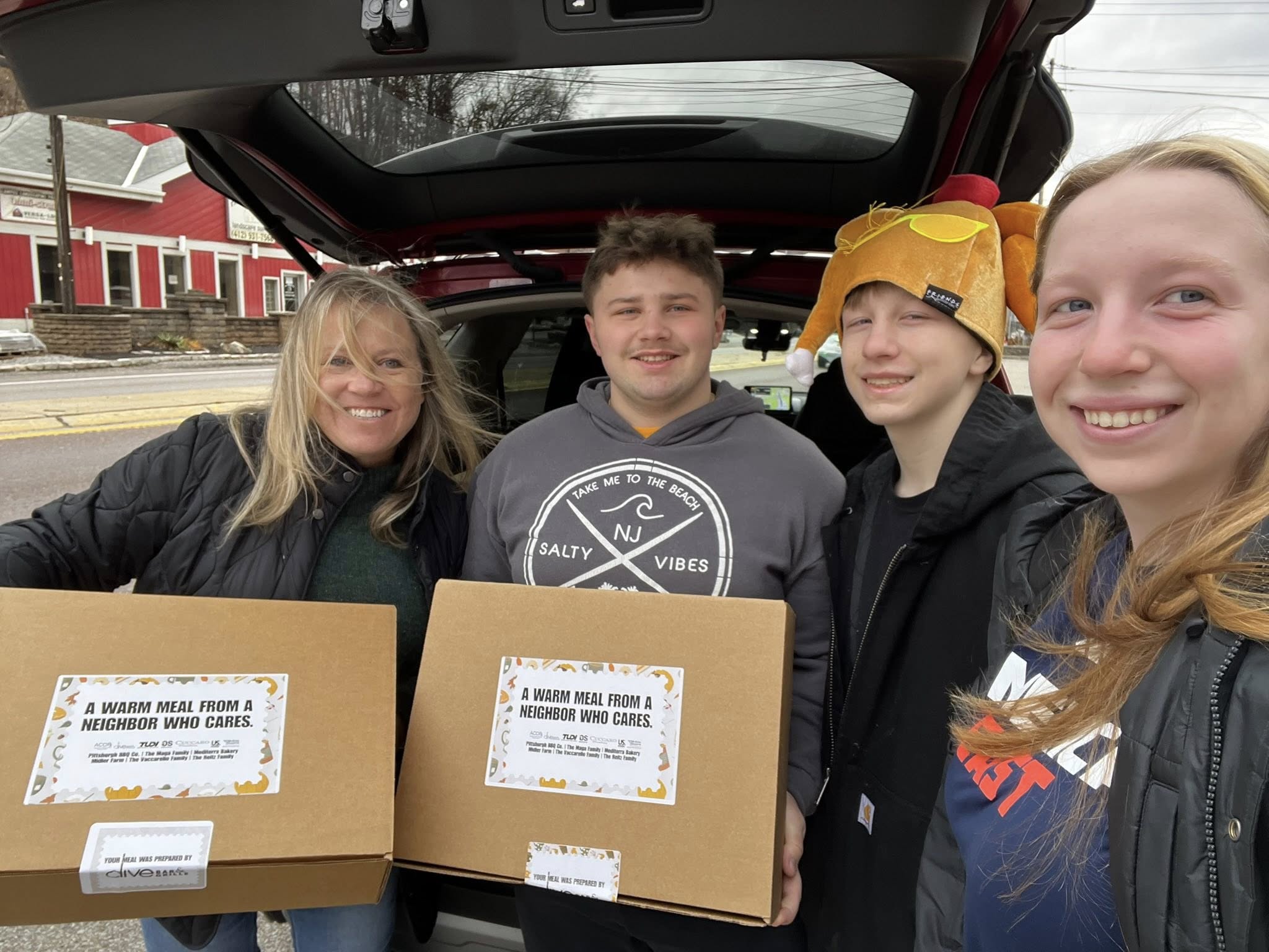 Two volunteers carrying YINZgiving meal boxes on delivery day