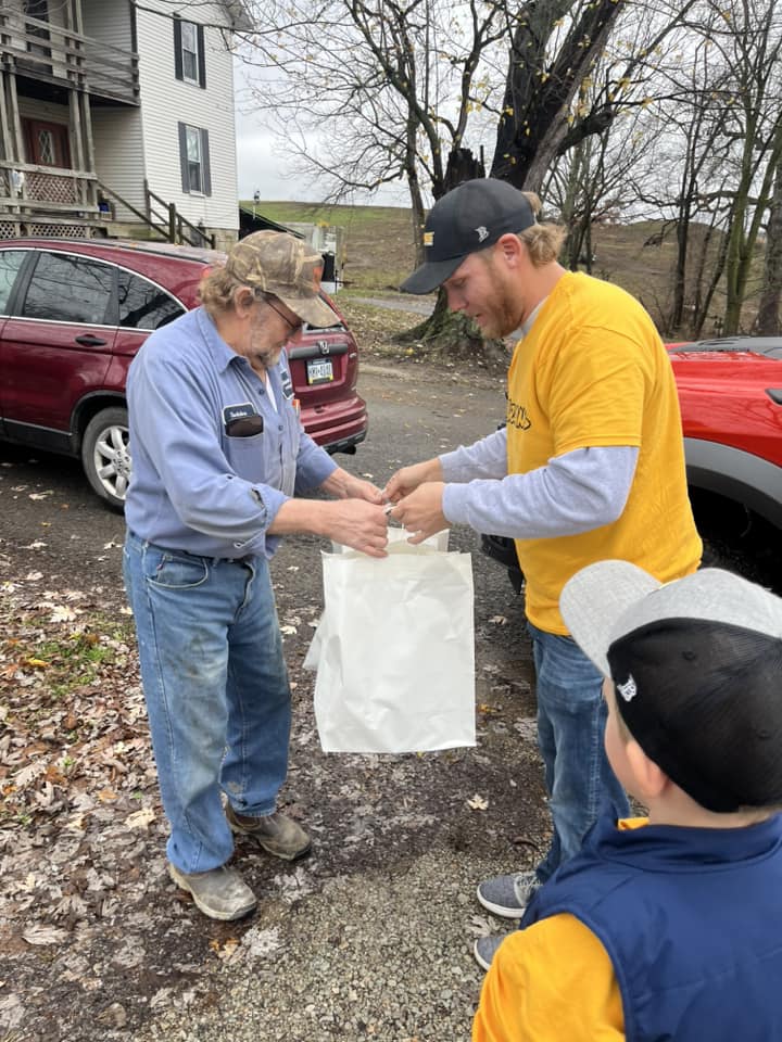 A YINZgiving volunteer delivering a Thanksgiving meal to a neighbor's door