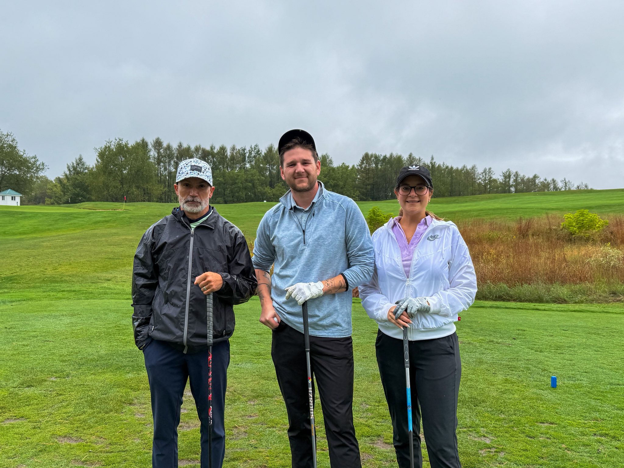 Three golfers on the tee box ready to play