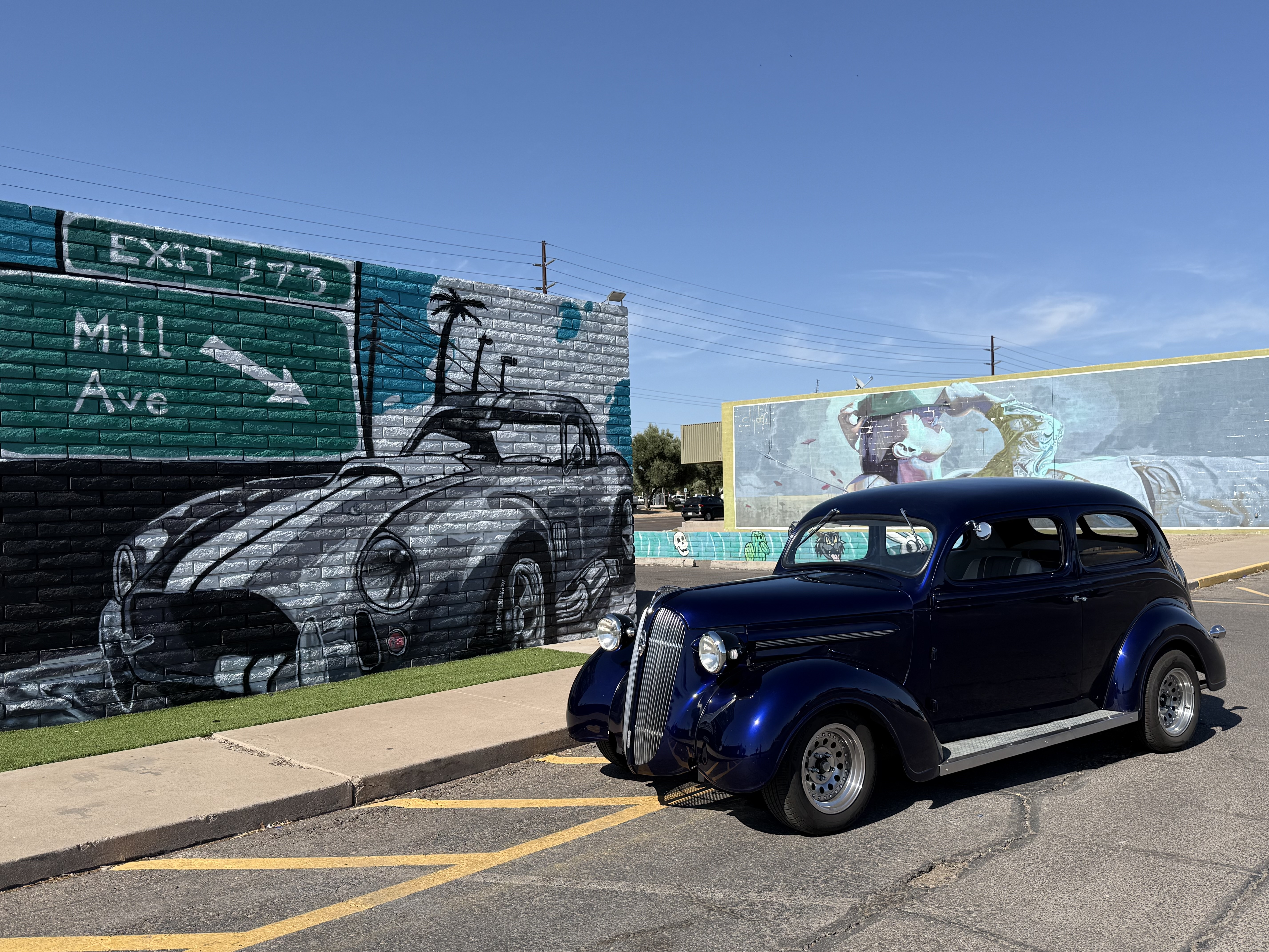 Classic deep blue car by the Bobby E's murals