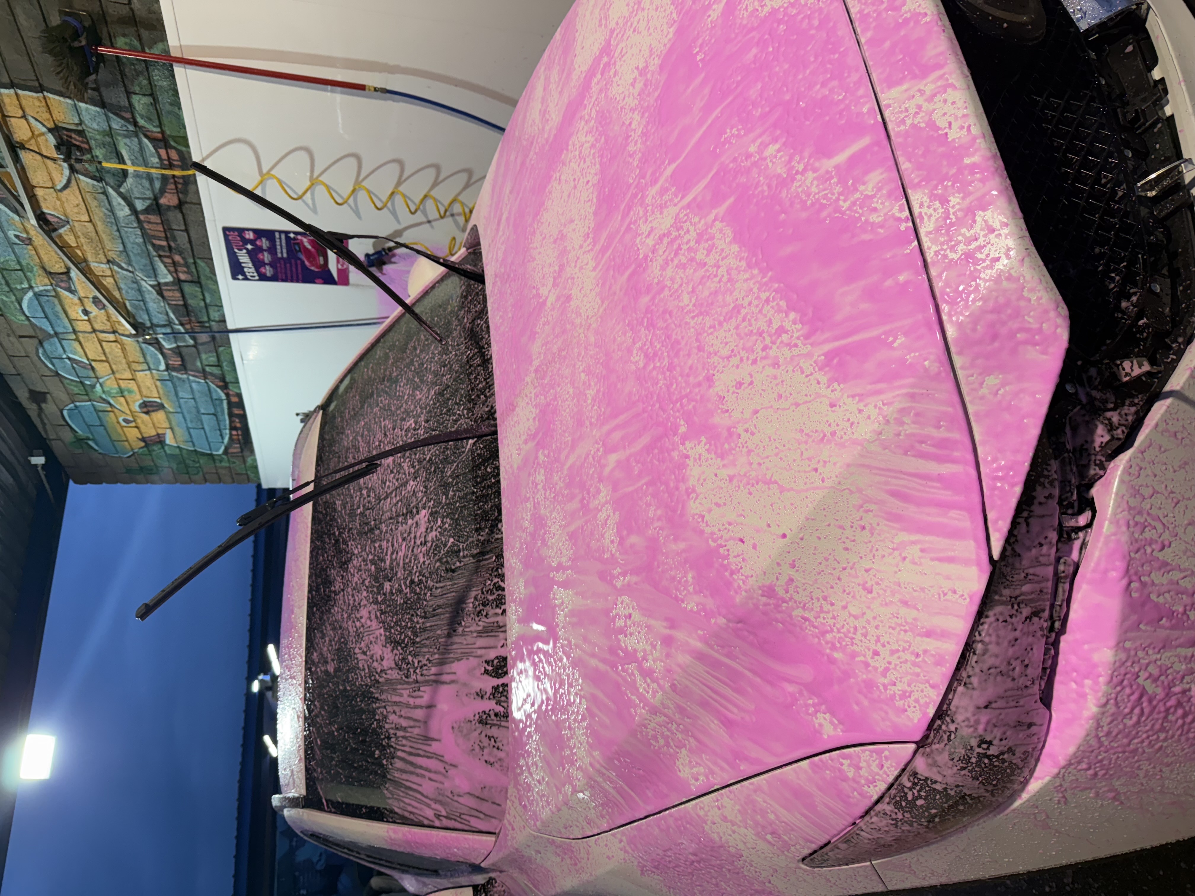 White car covered in pink ceramic soap at Bobby E's Car Wash, Tempe