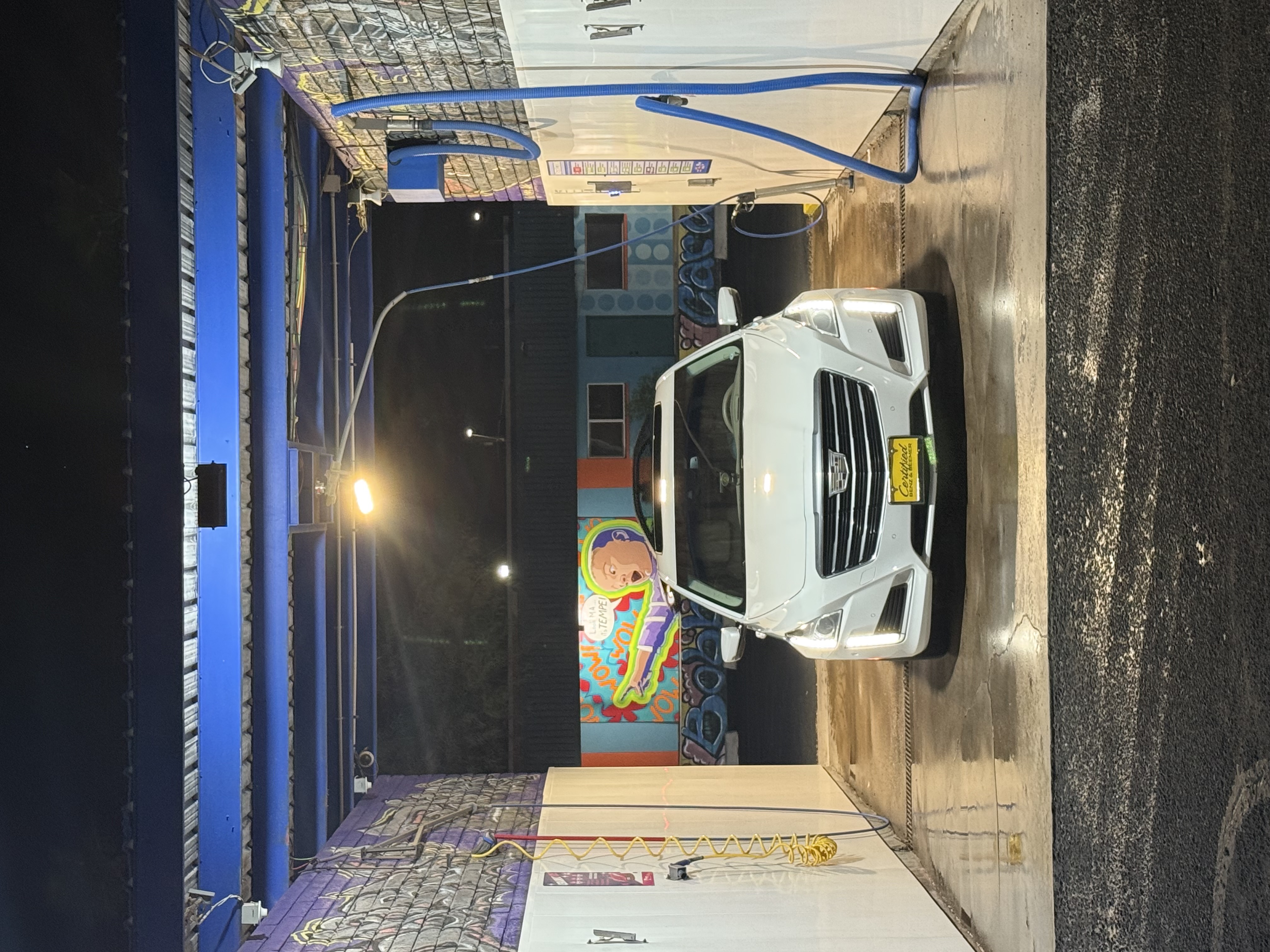 Bobby E's bays lit up at night in Tempe with a Cadillac being washed
