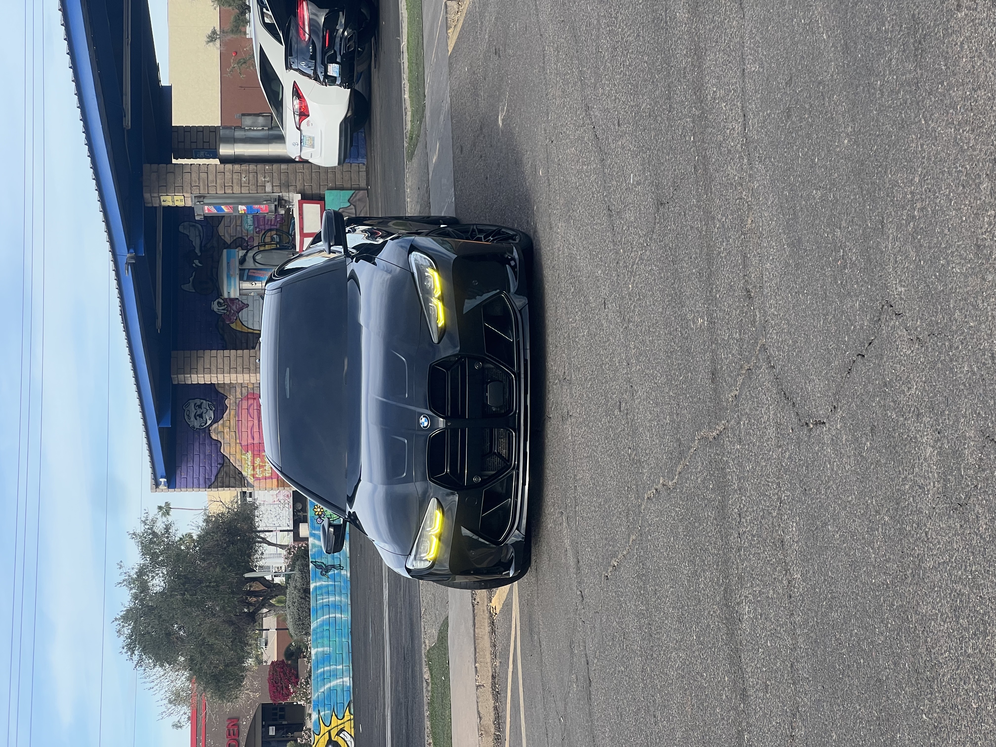 Black BMW M with yellow headlights leaving Bobby E's Car Wash, Tempe