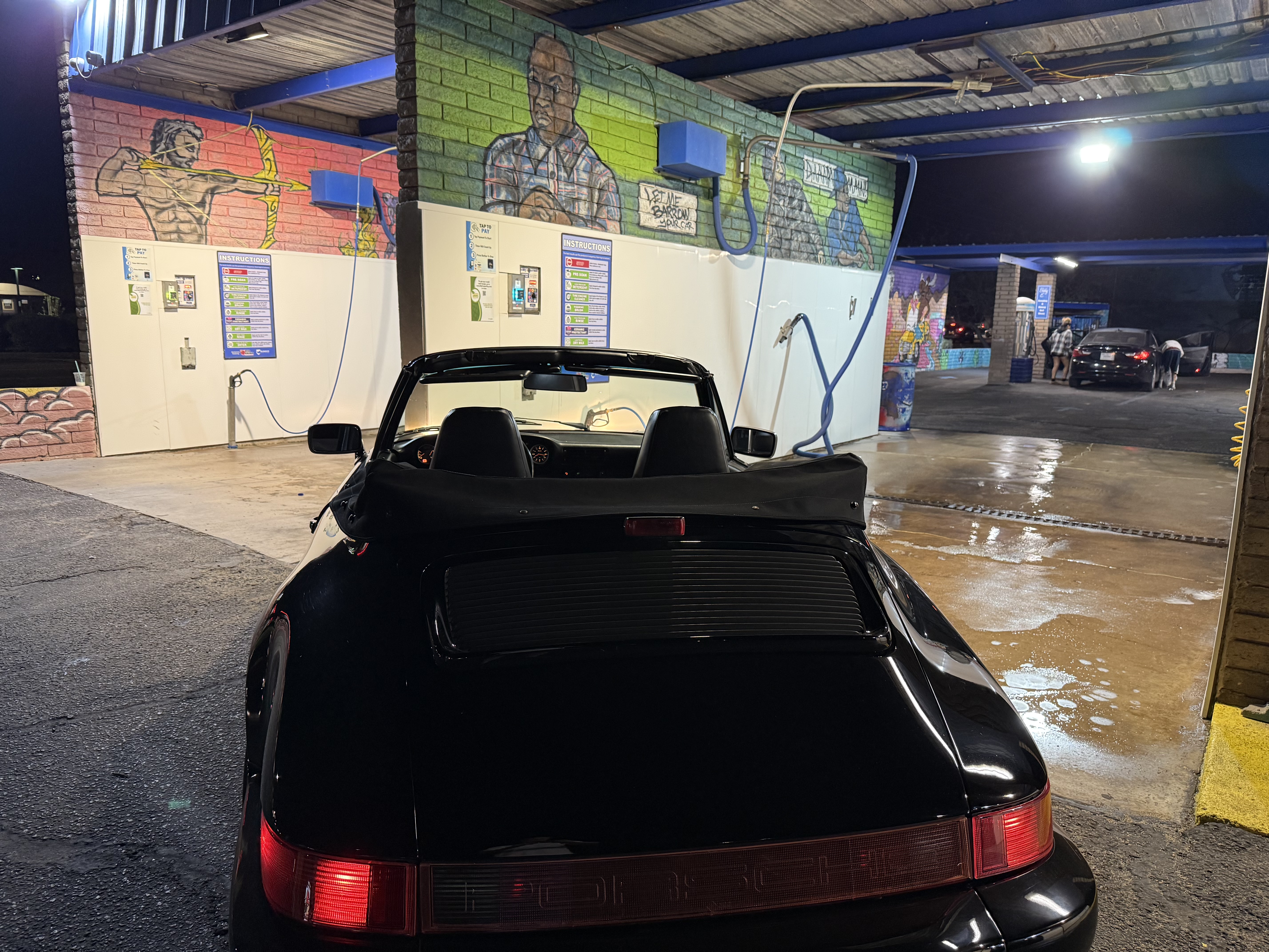 Black Porsche driving into a Bobby E's self-serve bay in Tempe