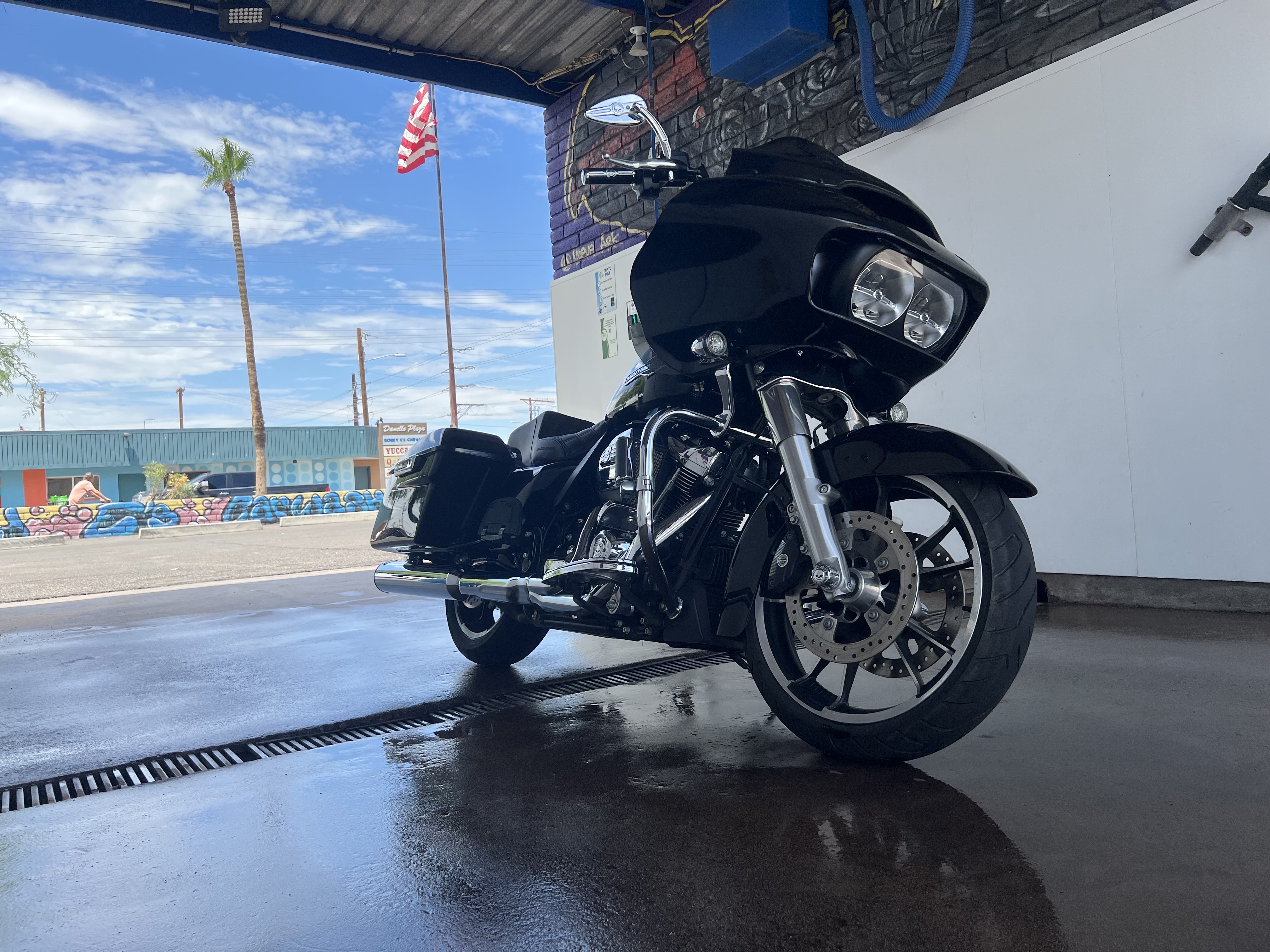 Black Harley in a Bobby E's bay with an American flag behind it