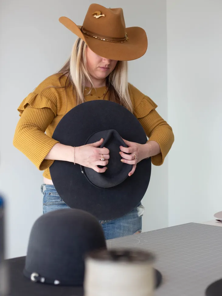 Hat shaper steaming and shaping a black felt hat at Ace High Hat Bar