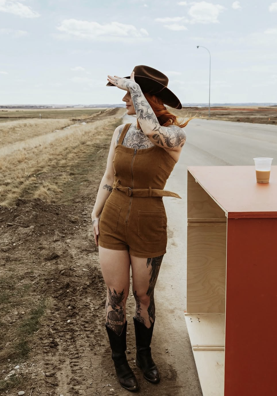 Woman in a custom felt hat on a prairie road