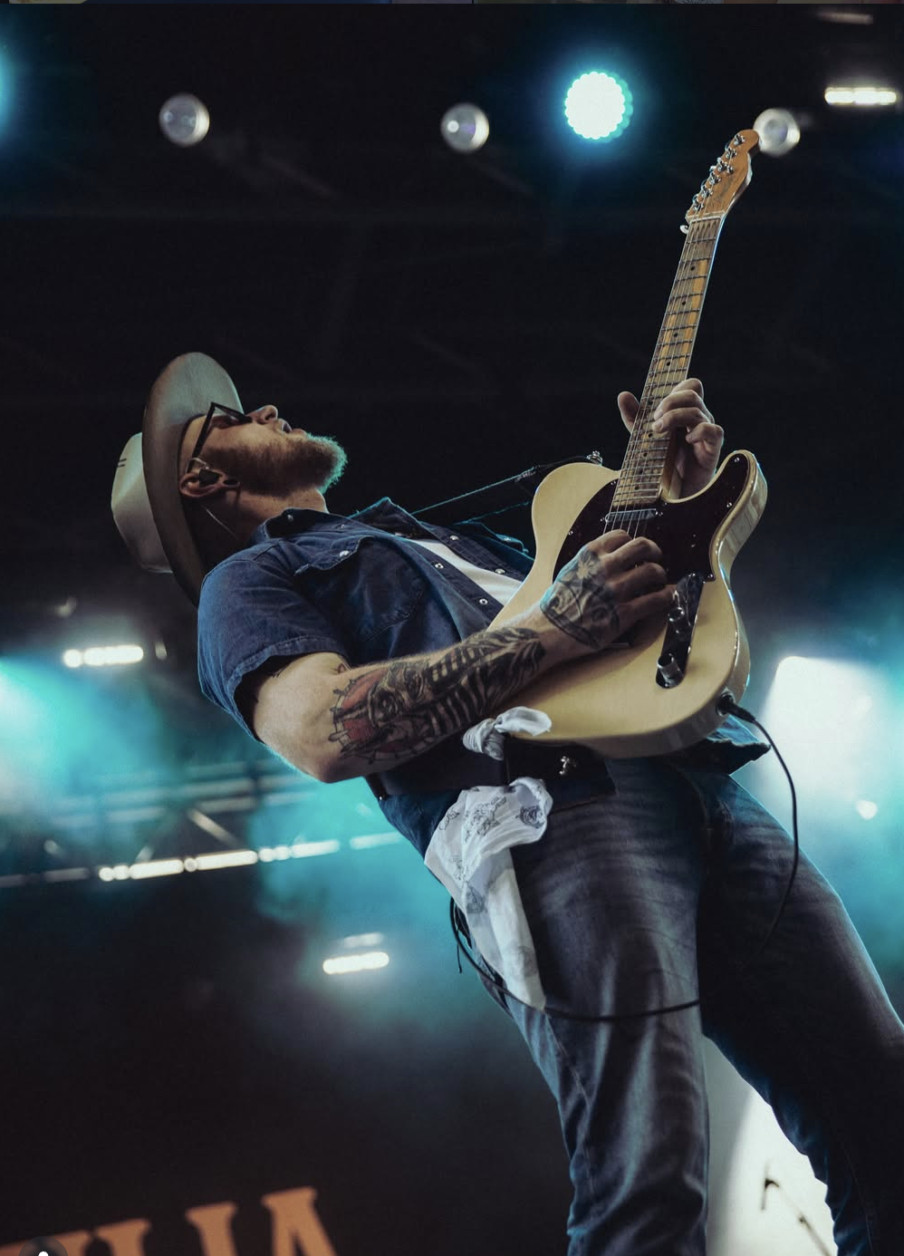 Musician performing on stage in an Ace High custom hat