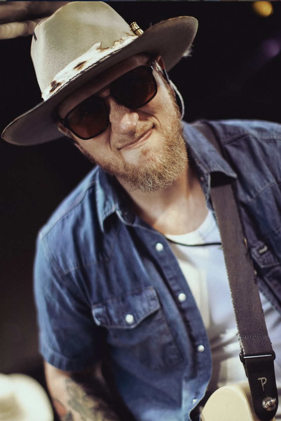 Smiling guest in a custom cowboy hat and sunglasses