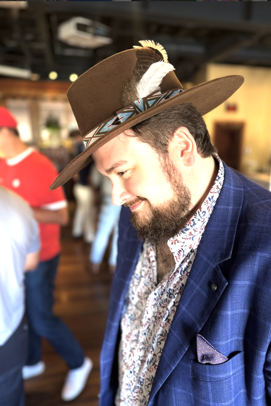 Guest in a custom felt hat with feather band at an event