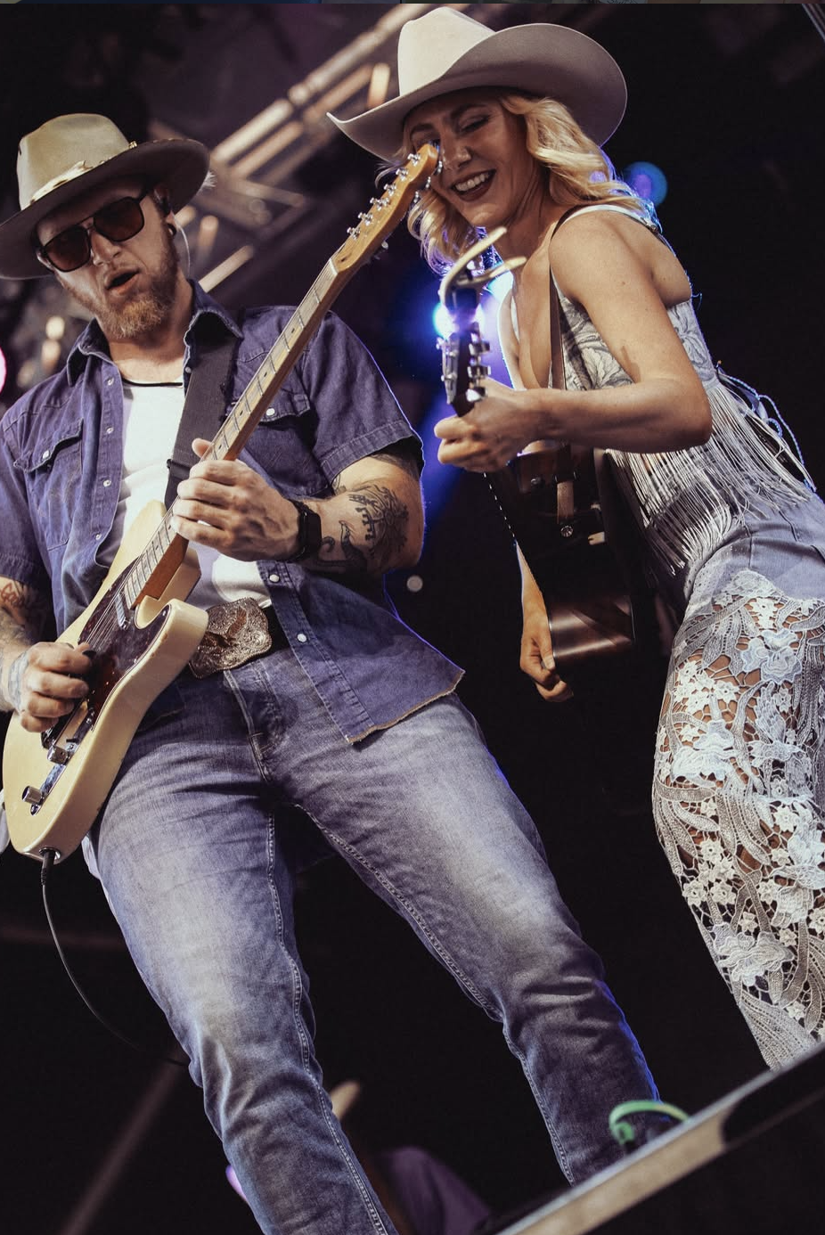 Couple dancing in custom hats at a Stampede-style event