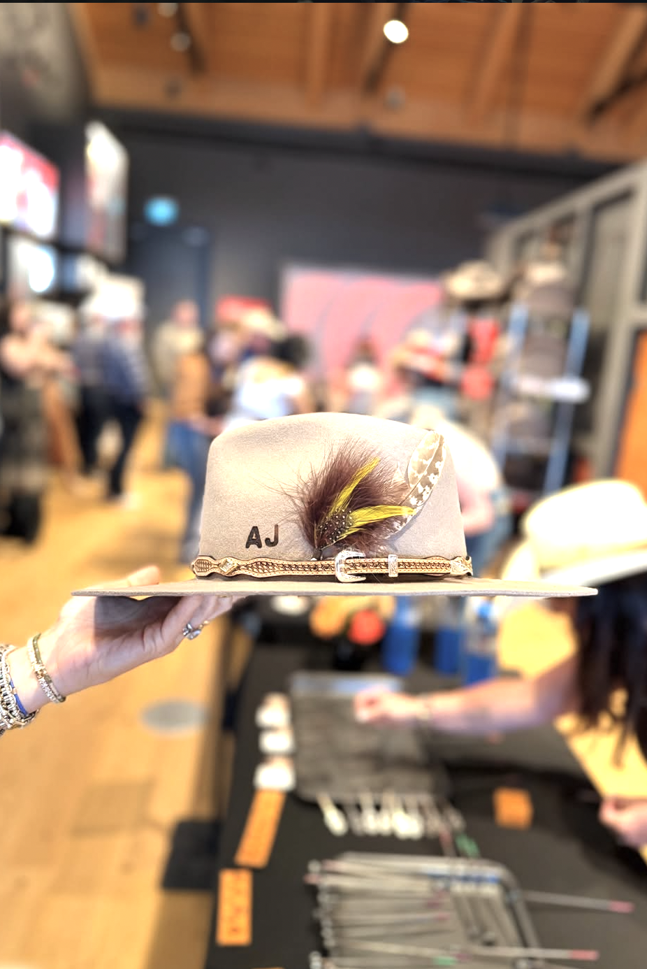 Hand-shaped hat with feather trim presented at an Ace High event
