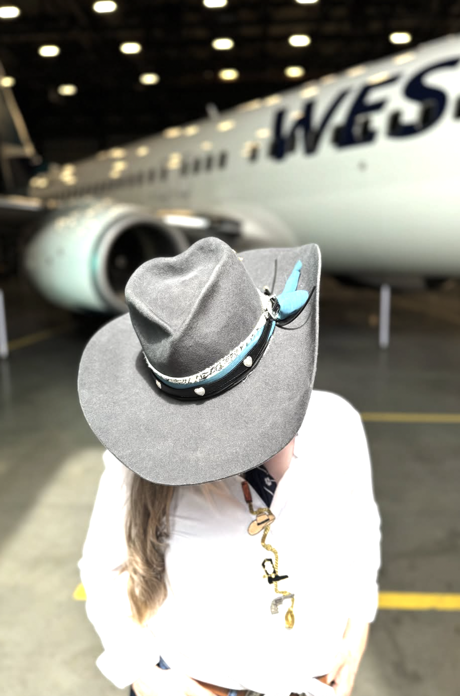 Guest wearing a grey custom hat at a corporate event in a hangar