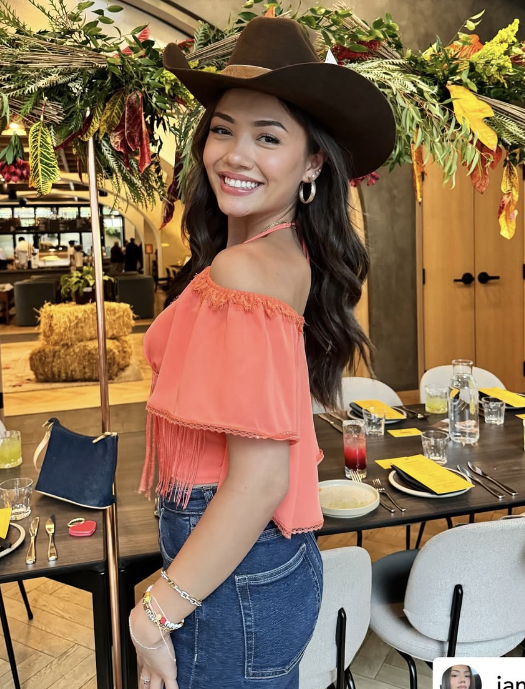 Smiling guest wearing a custom brown cowboy hat at an event