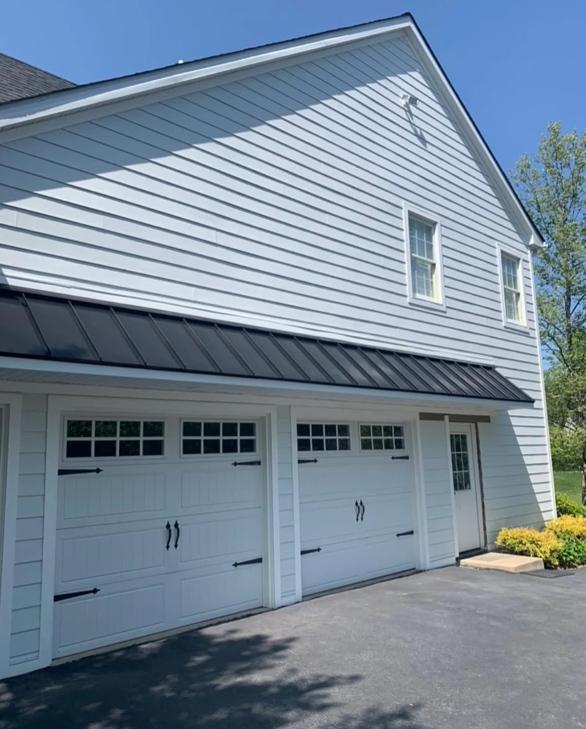 Residential exterior with garage, metal roofing, and siding