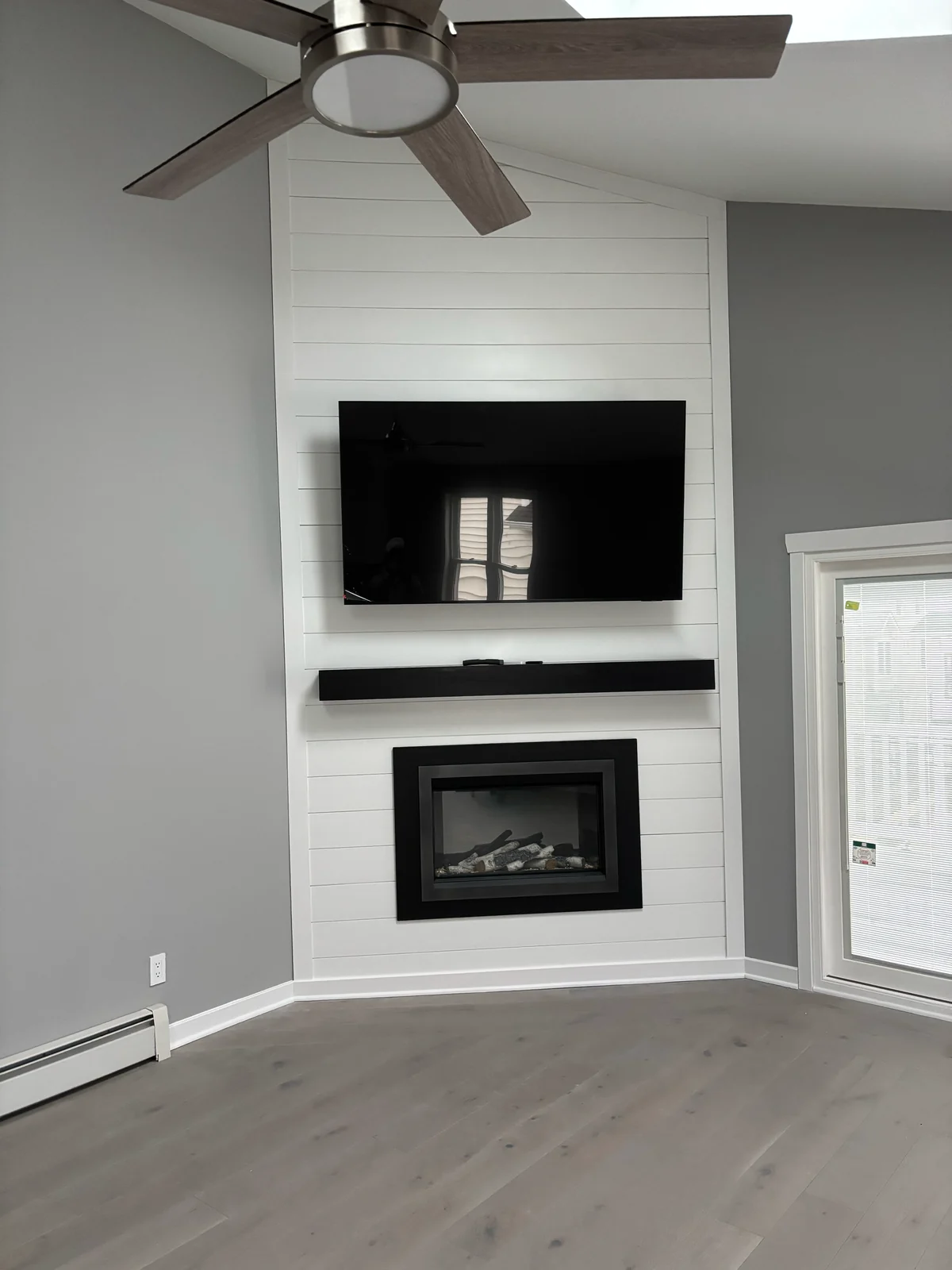 Living room remodeling work featuring a fireplace and shiplap wall by Michael John Contractors.