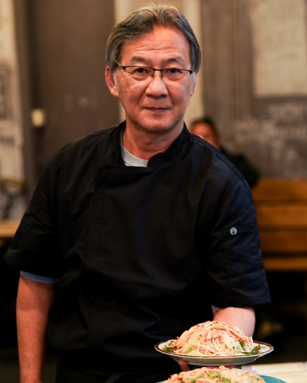 Our chef in the Phoodle dining room with plates of special fried rice and vermicelli salad