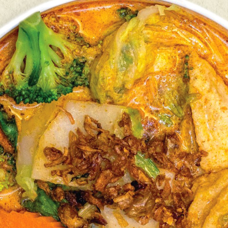 Tofu and vegetable laksa in spicy coconut curry broth