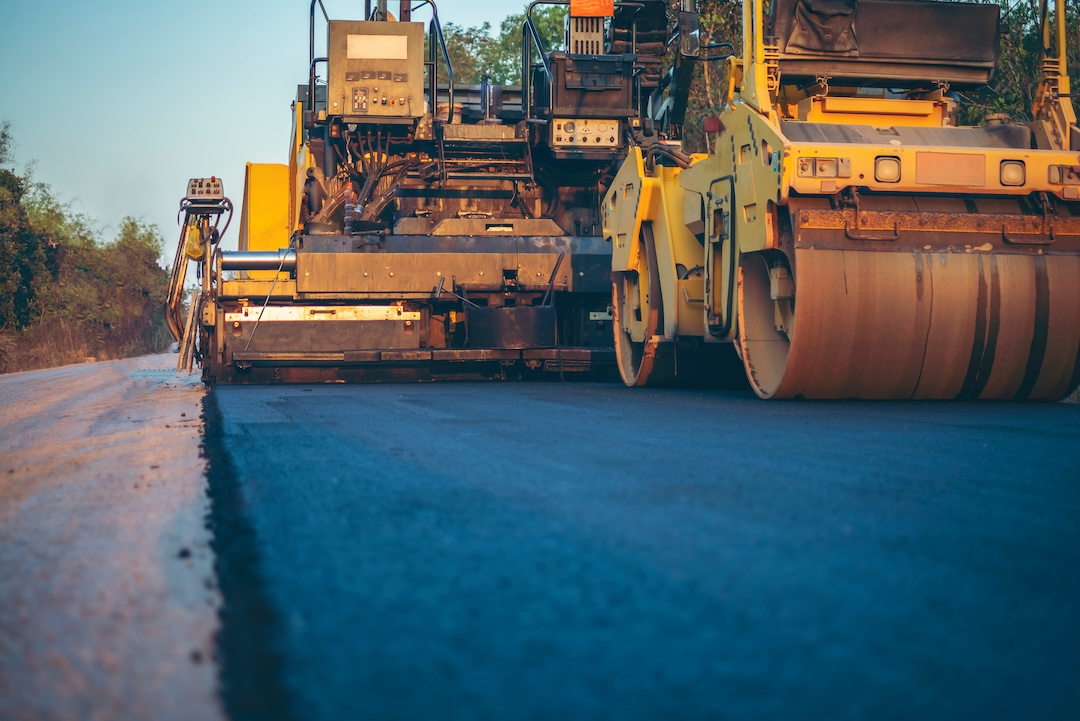 Asphalt paver and roller working in tandem