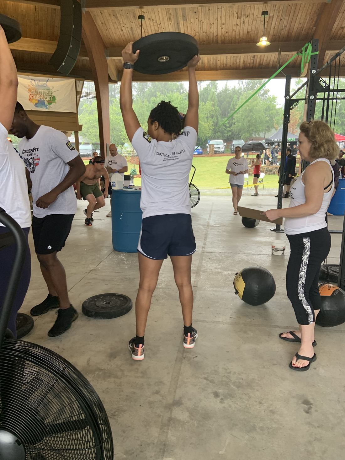 Shanti mid-competition, pressing a plate overhead