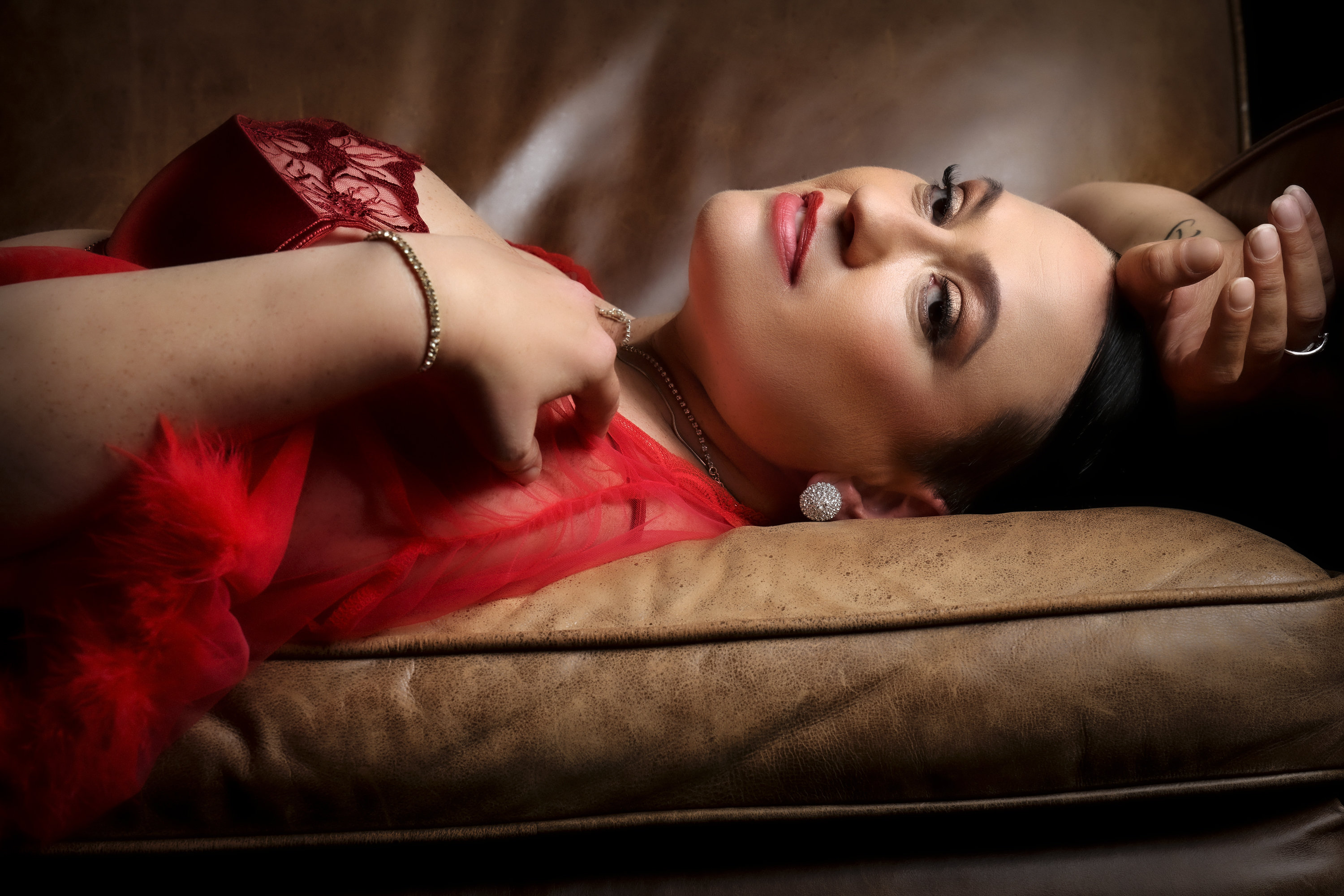 Portrait of a woman lying on a leather couch