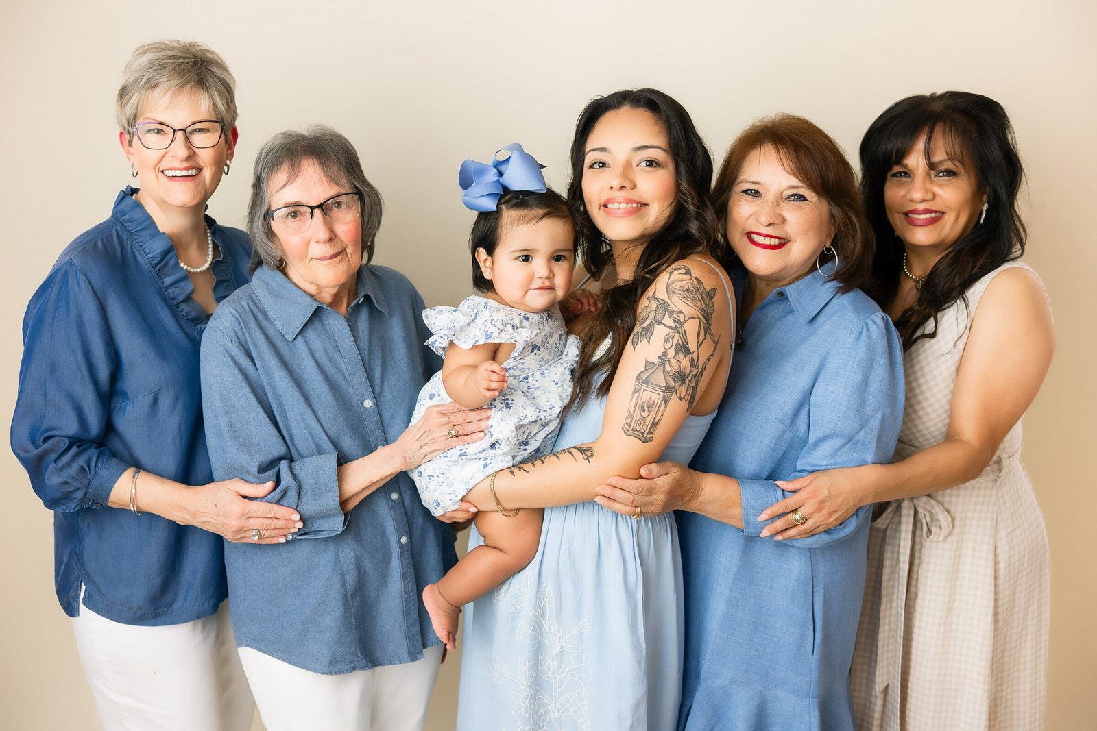 Four generations of women together in the studio, holding the youngest between them