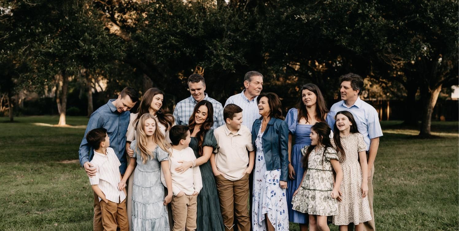 Extended family portrait outdoors under oak trees