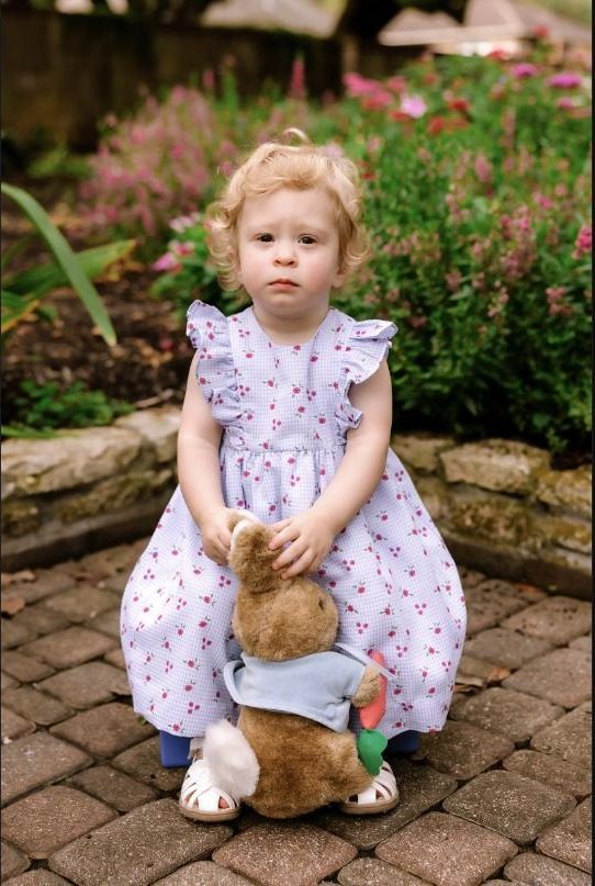 Toddler in a garden holding a stuffed bunny