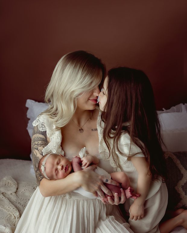 A mother and big sister holding a newborn