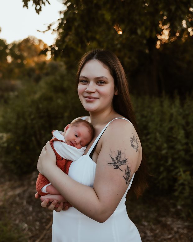 A mother outdoors with her newborn
