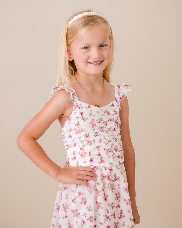 A young girl smiling in the studio against a soft backdrop