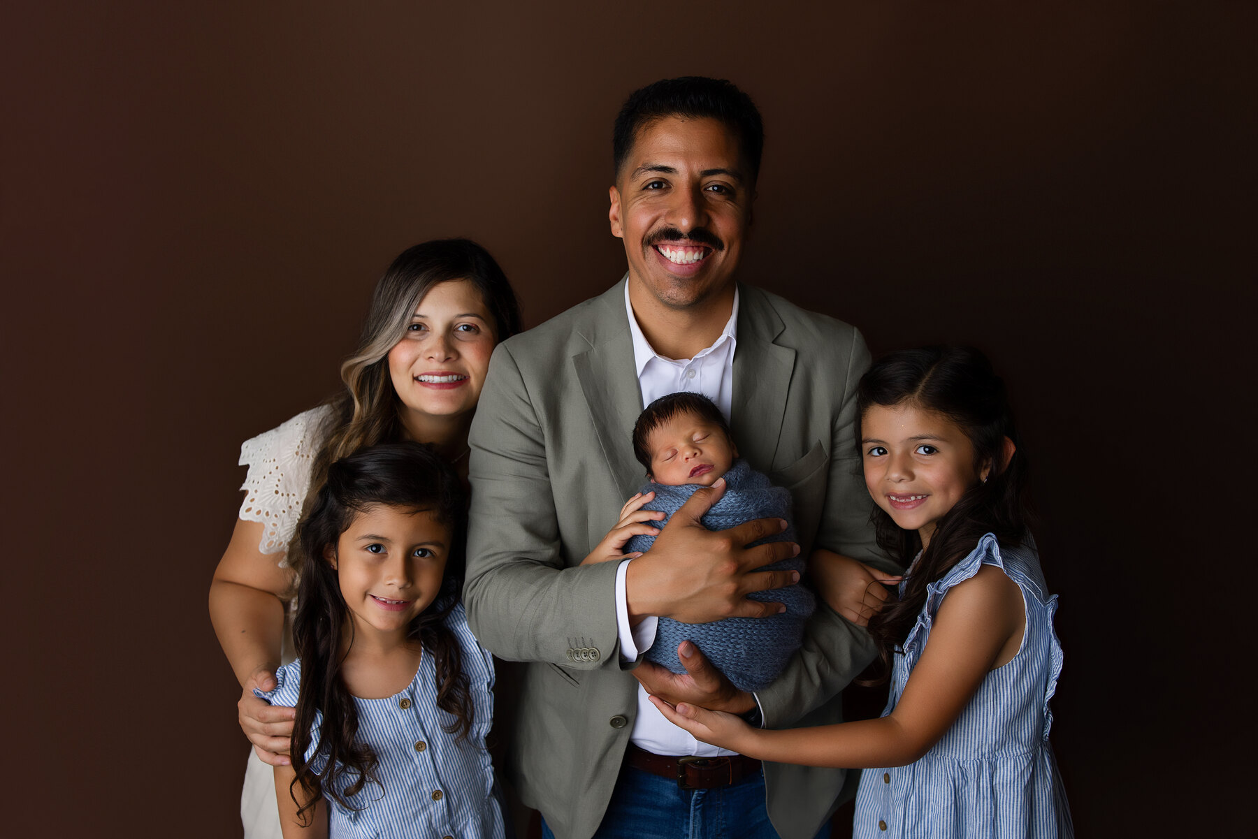 A family with their newborn during an Adorabella session