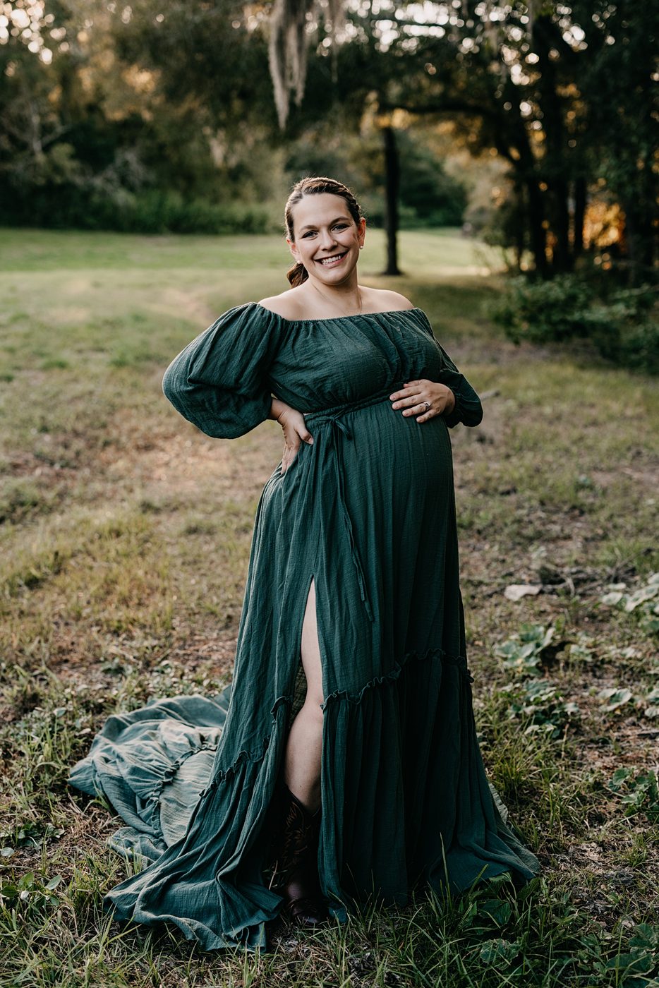 Expecting mother in a deep green gown at golden hour